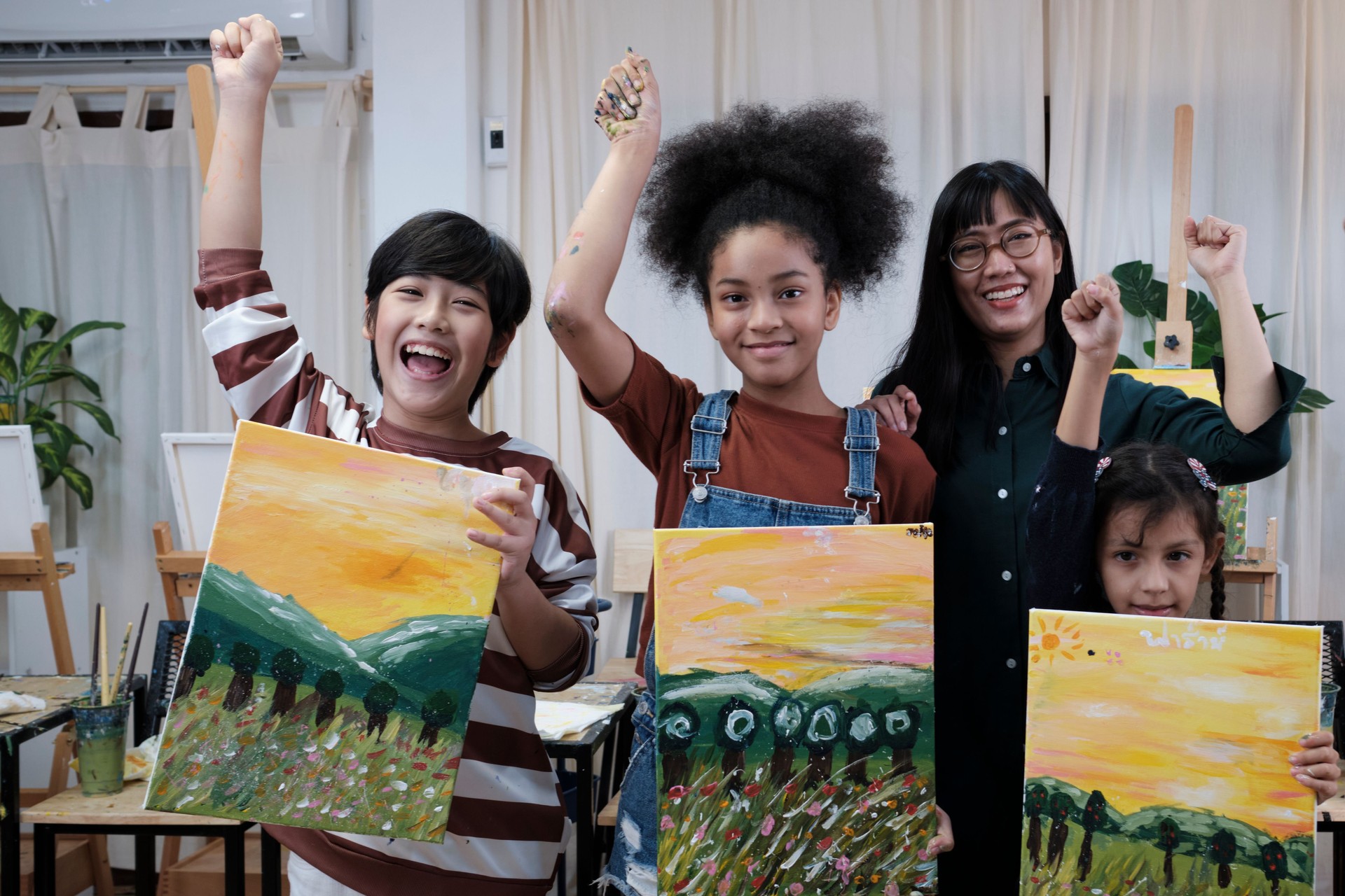 A teacher and students show painting work, an acrylic color picture on canvas.